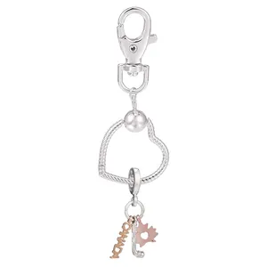 Porte-clés argenté et or rose avec pendentifs feuille d'érable et hockey Canada