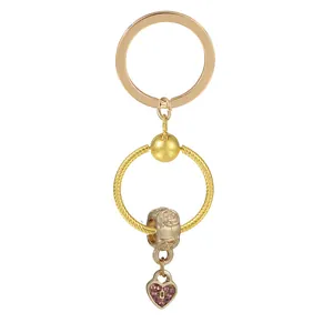 Porte-clés cœur doré avec strass rose et pendentif à plusieurs couches sur fond blanc