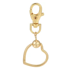 Détail d'un pendentif cœur doré avec texture de corde et fermoir mousqueton pivotant