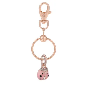Détail d'un porte-clés coccinelle en or rose avec émail rose et strass scintillants