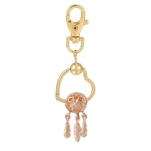 Porte-clés cœur doré avec breloque attrape-rêves et plumes en métal détaillées