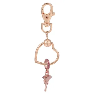 Porte-clés cœur en or rose avec un pendentif fleur de rose détaillé sur fond blanc pur