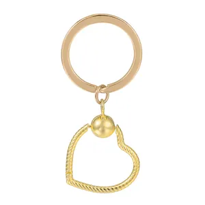 Détail d'un porte-clés doré avec un pendentif en cœur à texture de corde torsadée