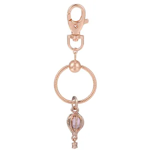 Porte-clés montgolfière or rose avec perle violette et fermoir mousqueton