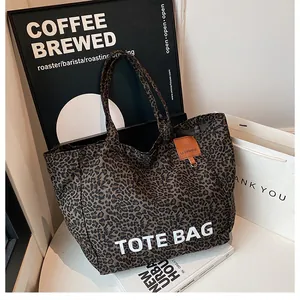 Detail of leopard print tote bag with white TOTE BAG text in a cozy urban lifestyle setting