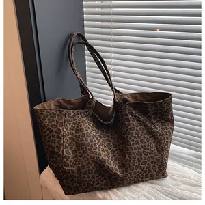 Detail shot of leopard print tote bag with long shoulder straps and spacious brown lining