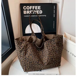 Detailed view of leopard print tote bag placed on a white desk with modern props