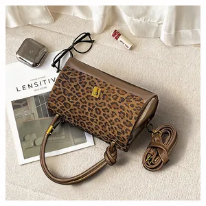 Dettaglio di stampa leopardata, chiusura dorata e tracolla regolabile su borsa stile retrò