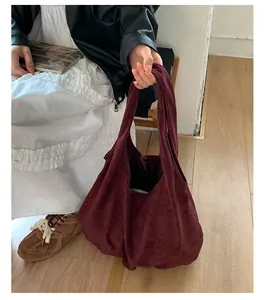 Dettaglio della borsa tote in pelle scamosciata bordeaux dalla grande capacità