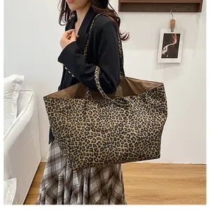 Model showcasing a large leopard print tote bag with a canvas texture for autumn commute