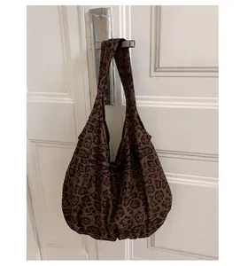 Dettaglio di una grande borsa tote leopardata appesa alla maniglia con tessuto morbido