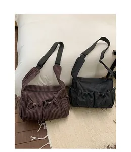 Dettaglio di borse in nylon a scacchi con tasche a coulisse e ampia tracolla nera