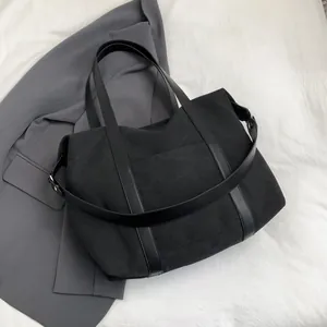 Grand sac cabas noir en toile avec bandoulière en cuir pour les trajets quotidiens