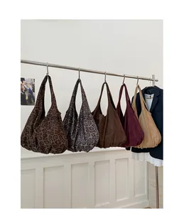 Dettaglio di grandi borse tote in finta pelle scamosciata con stampe leopardate