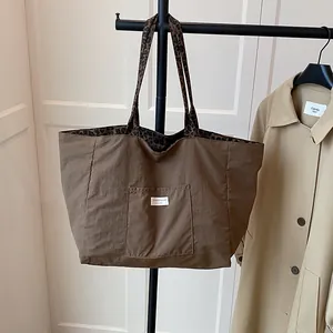 Brown tote bag with leopard print handles and outer pocket for autumn fashion style