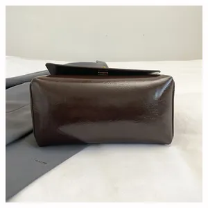 Dettaglio della base di una borsa in pelle oliata marrone che mostra forma e trama