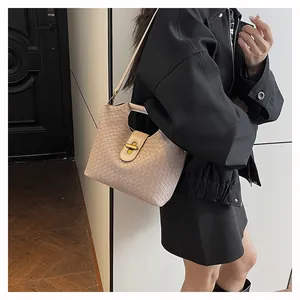 Dettaglio borsa in pelle intrecciata beige con chiusura dorata vintage e trama a scacchi