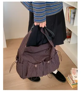 Dettaglio della borsa tote in nylon a quadretti con tasche a coulisse e tracolla