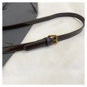 Dettaglio tracolla in pelle marrone scuro con fibbia dorata vintage e fori regolabili