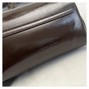 Dettaglio della pelle marrone scuro e logo impresso sulla borsa a mano vintage