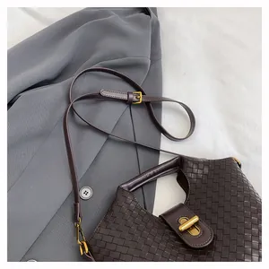 Dettaglio della pelle intrecciata marrone scuro e chiusura a girello in bronzo antico