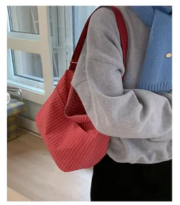 Dettaglio della capiente borsa tote in tela a quadri rossi con tracolla regolabile