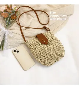 Detail of straw woven crossbody bag with brown leather flap and phone size comparison