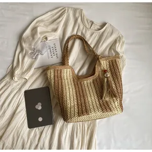 Vista piatta di una borsa tote a righe intrecciate con frange e oggetti di stile di vita