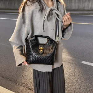 Secchiello in pelle intrecciata nera con chiusura in metallo dorato e tracolla chic