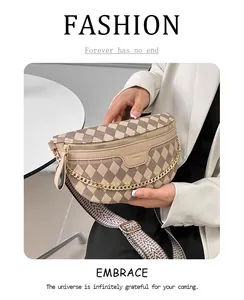 Close-up of beige quilted crescent crossbody bag with gold chain and wide woven strap