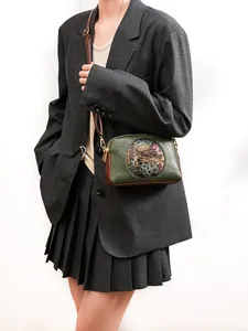 Detail of vintage double-layer crossbody bag with horse head emblem and green leather