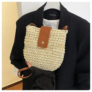 Detailed view of the woven straw texture and brown leather magnetic buckle closure
