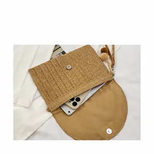 Detail view of woven envelope bag interior with magnetic clasp and pompom decoration