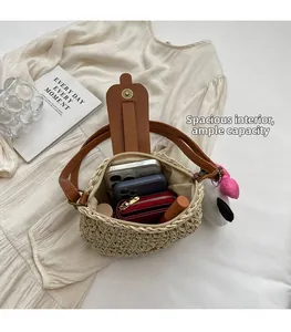 Vue de dessus de l'intérieur spacieux du sac en paille avec objets et breloque cœur rose