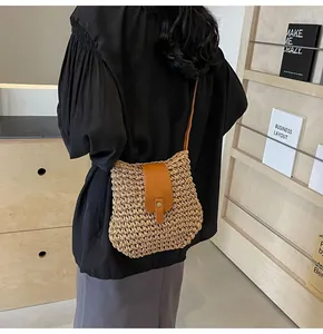 Détail du sac bandoulière en paille tissée à la main avec rabat et bandoulière en cuir