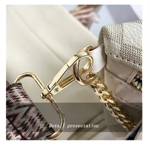 Close-up of golden hardware, chain, and detachable woven shoulder strap on the bag
