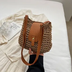 Détail du sac seau en paille avec bandoulière en cuir PU brun et fermoir en métal rétro