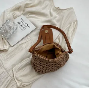 Vue de dessus d'un sac seau en paille tissé avec bandoulière en cuir PU marron foncé