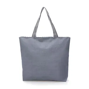 Minimalist grey canvas tote bag with black and white striped handles on white background