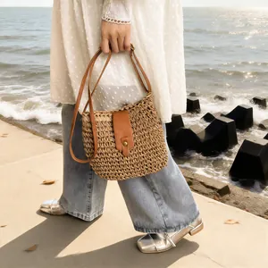 Handmade bohemian woven straw crossbody bag with brown leather strap for beach vacation