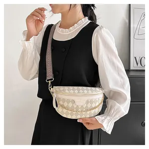 Detail of quilted beige crossbody bag with gold chain and geometric wide strap