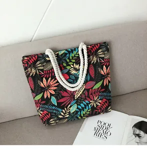 Détail d'un sac cabas à motif de feuilles tropicales avec poignées en corde de coton