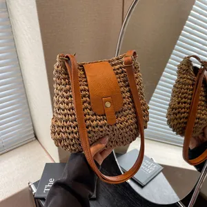 Détail du sac en paille tissé à la main avec bandoulière en cuir et boucle en métal