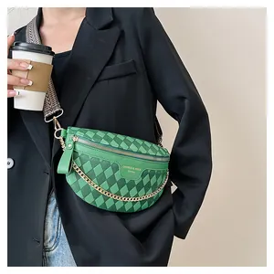 Detail of green checkerboard crossbody bag with gold chain and patterned strap