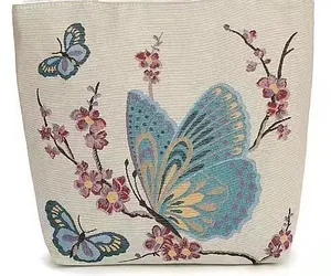 Dettaglio ricamo di farfalle e fiori colorati su borsa tote in tela color crema