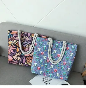Détail de sacs fourre-tout en toile avec anses en corde et motifs imprimés