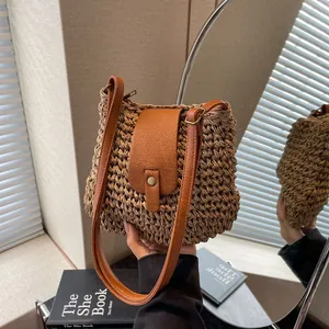 Détail de la texture du sac en paille tressée avec bandoulière et fermoir en cuir