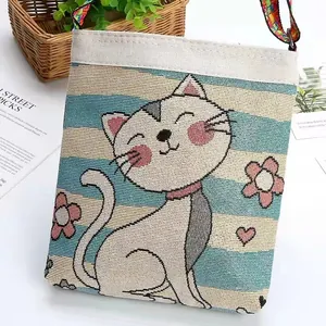 Dettaglio di una mini borsa tessuta con gatto ricamato e motivi floreali vivaci