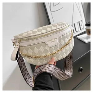 Detail of cream quilted chest bag with gold chain and patterned woven strap