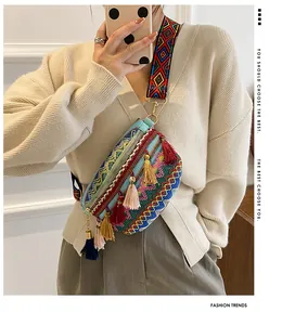 Close-up of geometric woven crossbody bag with colorful tassels and embroidered strap